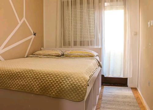 a bedroom with a bed with a large window at Apartman Lada in Bijeljina
