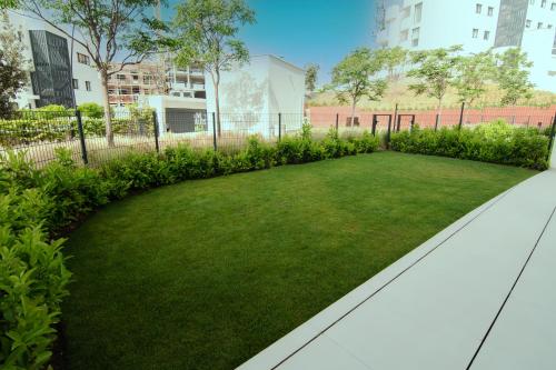 a garden with green grass and buildings at Mara's Apartments Higueron West - Like A House - 246 Square Meters of Private Terrace & Garden - Morning and Evening Sun in Fuengirola