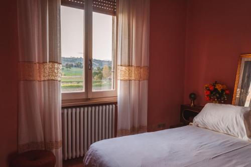 a bedroom with a bed and a large window at Casa di nonna in Bevagna