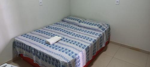 a bed with a blue and white blanket on it at A.N Hotel in Boa Vista