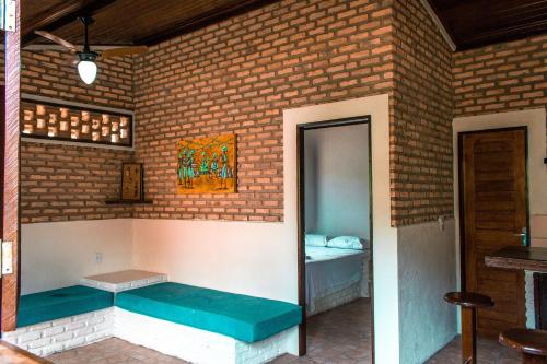 een kamer met een bed in een bakstenen muur bij Qavi - Chalé Rústico na Rua Principal #PortodoSol in Pipa