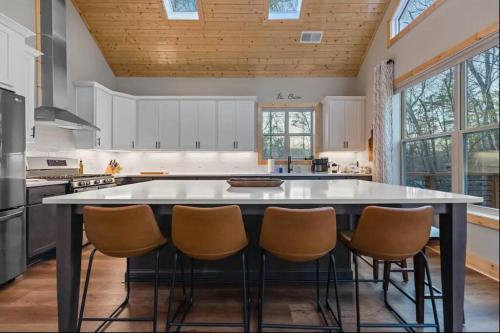 a kitchen with a large island with chairs around it at Peaceful Modern Chalet in Ellijay in Ellijay