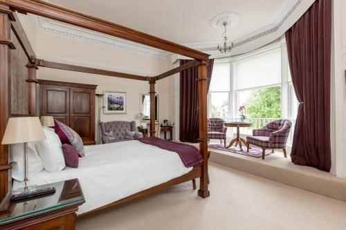 a bedroom with a canopy bed and a balcony at Victoria Square & The Orangery in Stirling