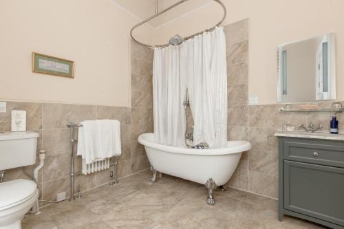 a bathroom with a tub and a sink and a toilet at Victoria Square & The Orangery in Stirling