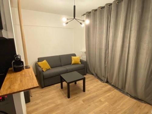 - un salon avec un canapé et une table dans l'établissement Bel appartement avec emplacement idéal, à Saint-Laurent-du-Var