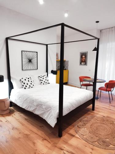 1 dormitorio con cama con dosel en blanco y negro en The Idyll Boutique Apartment - Spanish Quarter en Nápoles