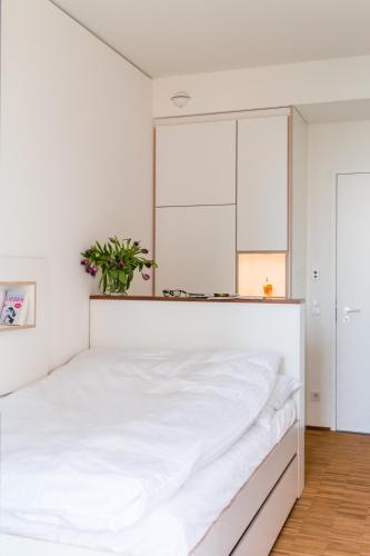 a bedroom with a white bed with a plant on it at Seminarhaus S1516 in Berlin