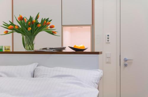 a bedroom with a vase of flowers and a mirror at Seminarhaus S1516 in Berlin