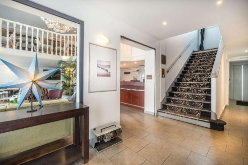 a living room with a staircase and a stair case at Sure Hotel By Best Western Lorient Centre in Lorient