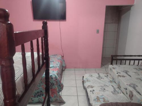 a bedroom with two bunk beds and a flat screen tv at Apartamento Encantador in Guaratinguetá