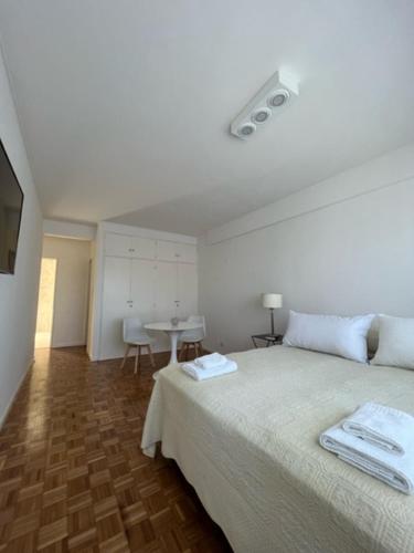 Dormitorio blanco con cama y mesa en POLO PREMIUM STUDIO - BUENOS AIRES en Buenos Aires