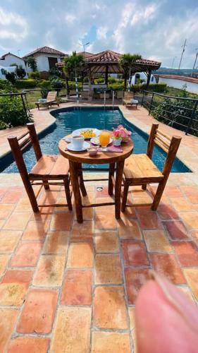 a table and two chairs next to a pool at Hermoso Glamping Santorini in Barichara