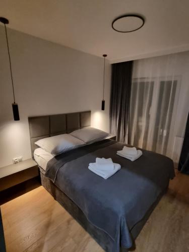 a bedroom with a bed with two towels on it at Premium Apartments Rzeszów Silver in Rzeszów