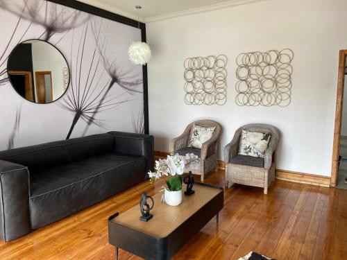 a living room with a black couch and a mirror at Boma choma in Beaufort West