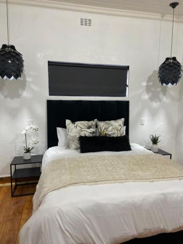 a bedroom with a large bed with a black headboard at Boma choma in Beaufort West