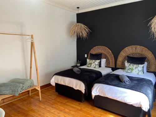 a bedroom with two beds and a black wall at Boma choma in Beaufort West
