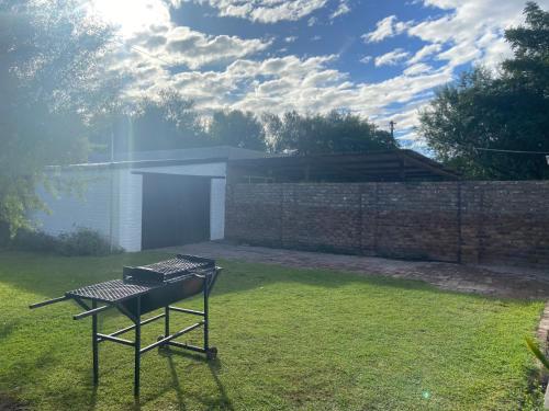 a barbecue grill in a yard with a brick wall at Boma choma in Beaufort West