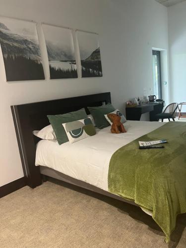 a bed with a teddy bear sitting on top of it at Le B Complexe Hôtel in Lozanne