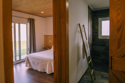 a bedroom with a bed and a window and a door at Forno House - Ameixoeira in Vila Praia de Âncora