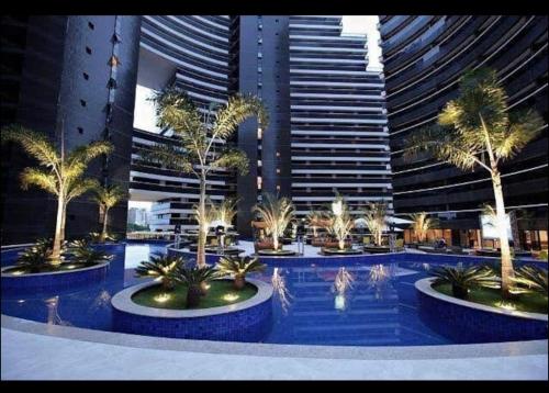 a large pool with palm trees in front of tall buildings at Fortaleza Landscape Beira-mar: espaço inteiro in Fortaleza