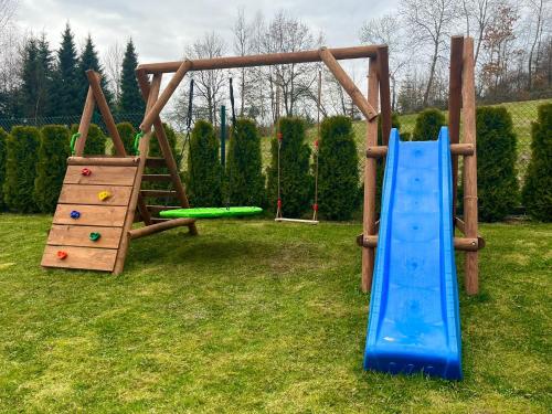 a playground with two slides and a climbing frame at Domek na Cedrowej in Bierna