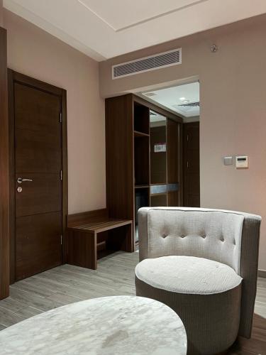 a room with a bed and a chair and a door at Violet Al Shisha Hotel in Makkah