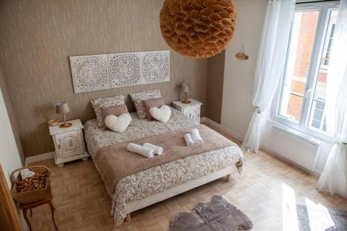 sypialnia z łóżkiem i dwoma ręcznikami na nim w obiekcie Appartement Un moment d’ÉVAsion w Épernay