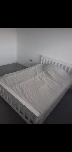 uma cama branca numa sala com em Short and Long Night Stay - very close to Gatwick and City Centre - Private Airport Holiday Parking - Early Late Check-ins em Crawley