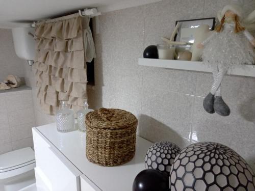 a bathroom with a toilet and a shelf with baskets at Casa Maria in Scauri