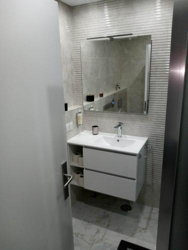 a bathroom with a white sink and a mirror at Flat in Olhão city center in Olhão