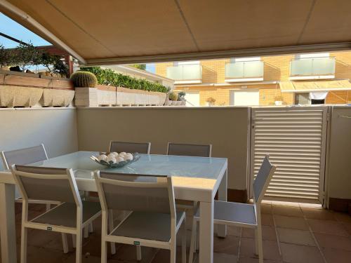 Casa en la playa con piscina في كوبيليس: طاولة بيضاء وكراسي على شرفة مع طاولة وكرسي