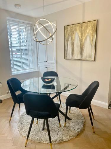 a dining room with a glass table and chairs at Heather Mere Cottage, Bowness-on-Windermere in Bowness-on-Windermere