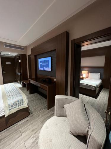 a hotel room with a bed and a television at Violet Al Shisha Hotel in Makkah