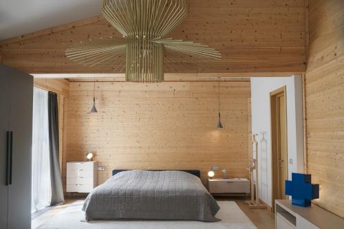 sypialnia z łóżkiem i drewnianą ścianą w obiekcie Sami Mta Chalet w mieście Mestia