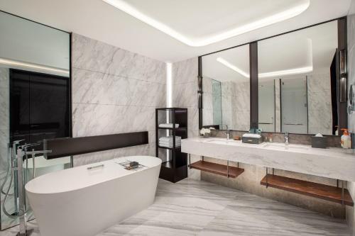 uma casa de banho com 2 lavatórios e uma banheira em Crowne Plaza Zhengzhou High Tech Zone, an IHG Hotel em Zhengzhou
