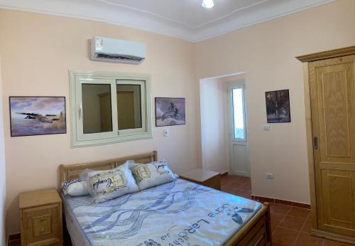 1 dormitorio con cama, espejo y ventana en Maison sur plage en Al Ḩammām