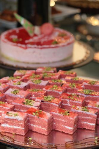 a bunch of pink cakes on a table with a cake at Violet Al Shisha Hotel in Makkah