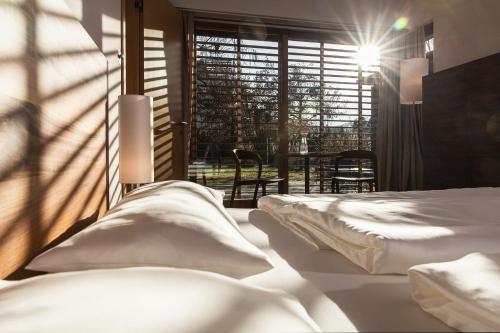 1 dormitorio con 2 camas, mesa y ventana en Urlaubsoase Klagenfurt am Wörthersee en Klagenfurt