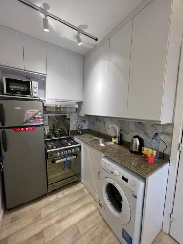 a kitchen with white cabinets and a washer and dryer at Madinaty, Elite new studio families and married couples only in Madinaty