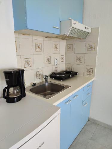 a kitchen with a sink and a microwave at Kleanthi Apartments in Drios
