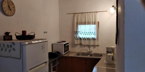 una pequeña cocina con fregadero y microondas en Traditional House in Elounda en Eloúnda