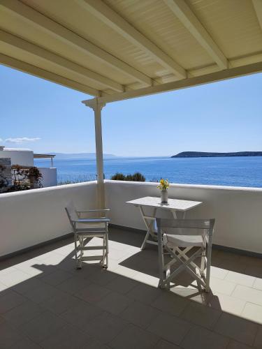 a table and two chairs on a balcony with the ocean at Kleanthi Apartments in Drios