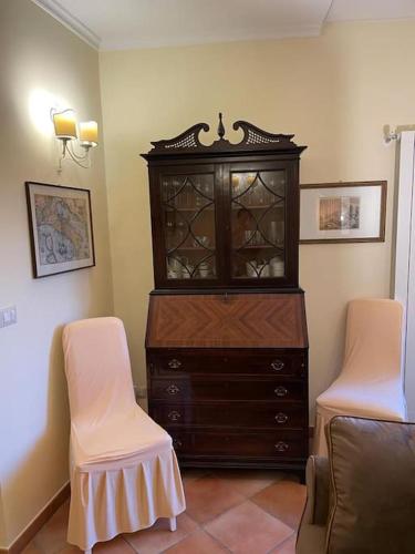a living room with a dresser and two chairs at Torre delle rondini in Castelnuovo di Farfa