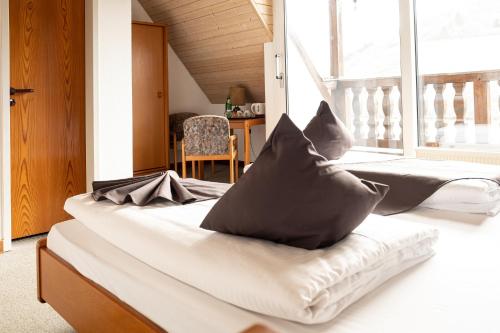 two beds in a room with a large window at Mike‘s Mosel Lodge in Treis-Karden