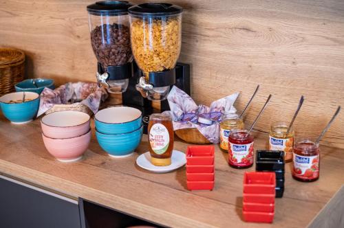 a wooden counter with a bunch of bowls and jars of food at Mike‘s Mosel Lodge in Treis-Karden