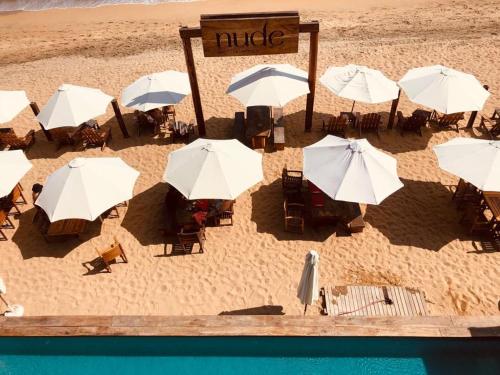 an overhead view of a beach with tables and umbrellas at Hotel Nude Zipolite & beach club in Zipolite