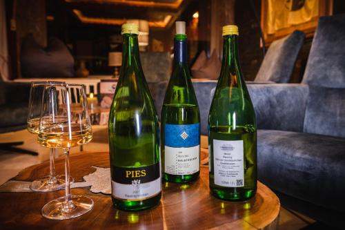 three bottles of wine sitting on a table with glasses at Mike‘s Mosel Lodge in Treis-Karden