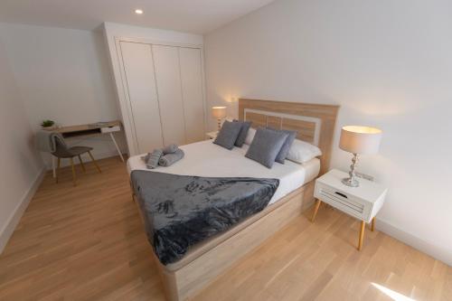 a bedroom with a bed and a desk in it at Brand New Luxury 1 Bed 2 Bath Apartment - SPA, Pool & Gym in Gibraltar