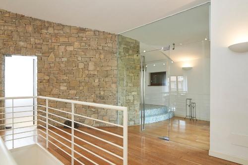 baño con ducha a ras de suelo y pared de piedra en [Milan-Como Lake-Rho Fiera] Luxury Design Villa, en Barlassina