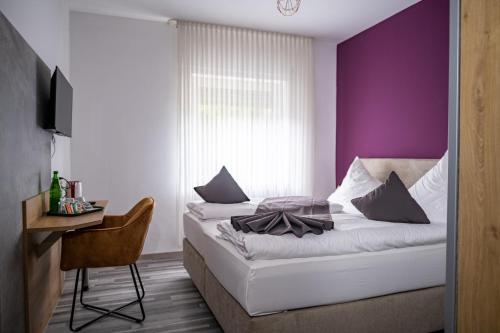 a bedroom with a bed with a purple wall at Mike‘s Mosel Lodge in Treis-Karden